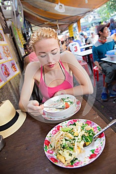 Traveler eating traditional thai Tom Yum soup.