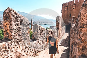 Traveler exploring the city of Alanya in Turkey. Woman walking and discovering old landmark in Europe.