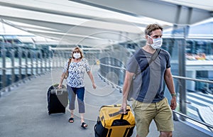 Traveler with face mask affected by coronavirus travel ban and COVID-19 pandemic flight restrictions