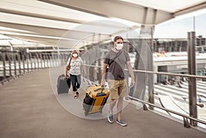 Traveler with face mask affected by coronavirus travel ban and COVID-19 pandemic flight restrictions