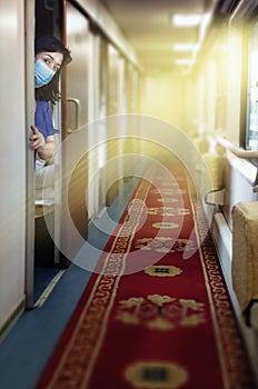 Traveler in a face protective mask peeks out from the compartment door