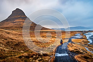 Traveler at famous Kirkjufellsfoss waterfall in Iceland