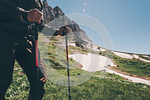 Traveler Feet hiking in mountains with trekking poles