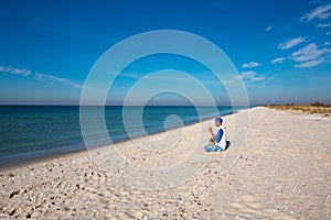 Traveler with funny dog sits on the deserted beach