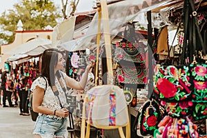 Traveler girl buying souvenirs in the traditional Mexican market in Mexico streets, hispanic tourists standing in outdoor Latin Am