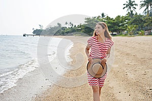 Traveler girl on empty tropical beach. Young woman walking relaxed on sand beach in Brazil. Escape travel concept