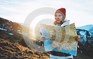 Traveler girl look and hold in hands map, people planning trip, hipster tourist on background sun flare nature, enjoy journey