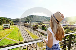 Traveler girl looking the old train station with clock tower of Paranapiacaba, Sao Paulo, Brazil photo