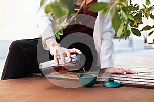 Traveler girl pouring tea in thermos cup, outdoors. Young woman drinking tea at cup. Theme travel. Woman pouring a hot drink in mu