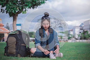 Traveler girl`s sitting under the tree on the nature background