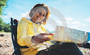 Traveler girl smiling looking on map, vacation trip, happy people planning trip, hipster tourist on nature, enjoy lifestyle