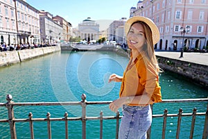 Traveler girl standing on the bridge with beautiful view of Trieste city, Italy