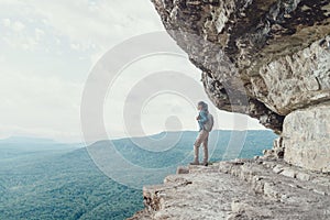Traveler girl standing on cliff.