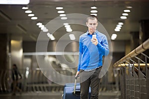 Traveler guy using phone at airport