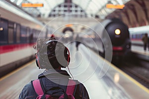 traveler with headphones on highspeed train platform