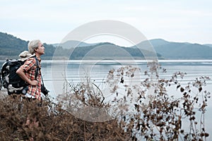 traveler hiker man with backpack hiking near lake. tourist backpacker relaxing in forest. travel lifestyle, summer vacation