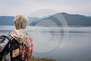 traveler hiker man with backpack hiking near lake. tourist backpacker relaxing outdoor. travel lifestyle, summer vacation concept