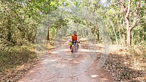 Traveler with his bicycle loaded with bags smiling on a rural road