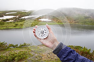 Traveler holding a compass and pointing direction