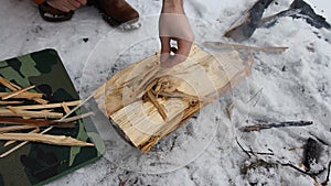 Traveler kindle fire using flint, in place for bonfire made of rough stone covered with frost. Starting fire with