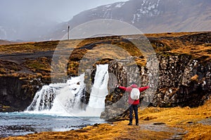 Traveler at Kirkjufellsfoss waterfall in Iceland