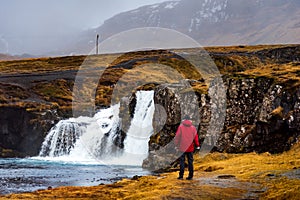 Traveler at Kirkjufellsfoss waterfall in Iceland