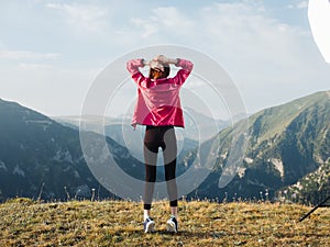 A traveler in leggings, sneakers and a jacket are resting in the mountains in nature photo