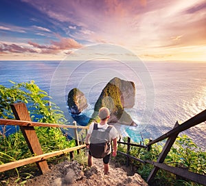 Traveler look at the ocean and rocks. Travel and active life concept. Adventure and travel on Bali, Indonesia.