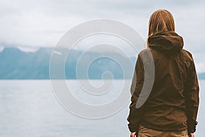 Traveler looking at fjord and foggy mountains view traveling in Norway