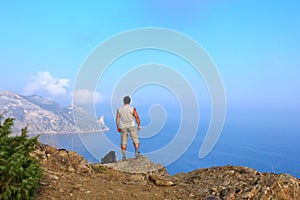 Traveler looks at the beautiful seascape from the mountain top