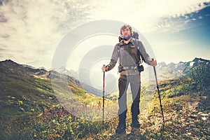 Traveler Man with backpack and trekking poles mountaineering