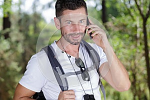 Traveler man backpacker using smart phone in forest