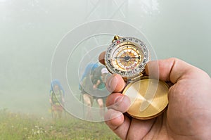 Traveler man with compass seeking a right way through the fog