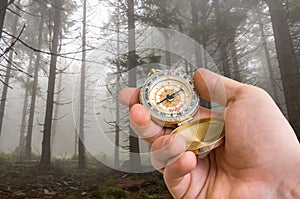 Traveler man with compass seeking a right way in the forest