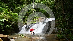 Traveler Man Enjoying Waterfall, Open Waterproof Bag and Take Mobile Phone
