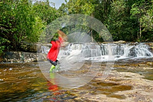 Traveler man enjoying in the Waterfall at Phu Kradueng national park, Loei Thailand, beautiful landscape of waterfalls in