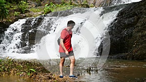 Traveler Man Exploring, Enjoying Nature of Beautiful Tropical Cascade Waterfall
