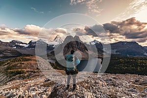 Traveler man hiking on Nublet peak with Assiniboine mountain and lake at provincial park