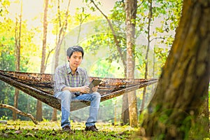 Traveler man hiking and relaxing in hammock autumn woods