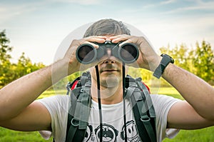 Traveler man looks through a binoculars