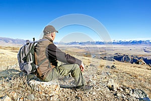 Traveler man in mountains in autumn or summer time.