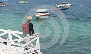 traveler man with red backpack standing on white bridge at KOH LARN, PATTAYA, THAILAND