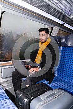 Traveler man sitting on train and typing on laptop