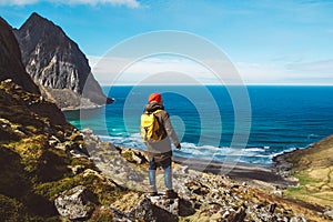Traveler man stand on cliff edge on the background of mountains, rocks and sea. Place for text or advertising