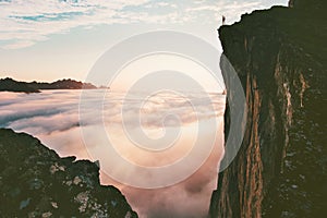 Traveler man standing on the edge cliff over clouds photo