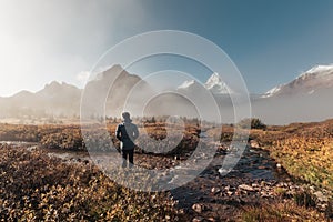 Traveler man standing and looking the mount Assiniboine in foggy on autumn forest at provincial park