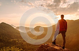 Traveler man standing on top of rock in the mountains.