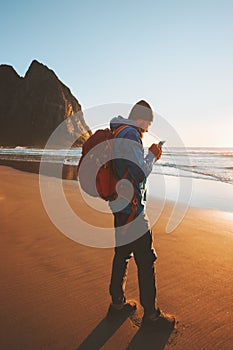 Traveler man with using smartphone on Kvalvika beach navigation technology