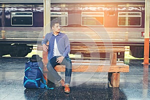 Traveler man waits train on railway platform