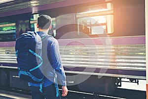 Traveler man waits train on railway platform photo